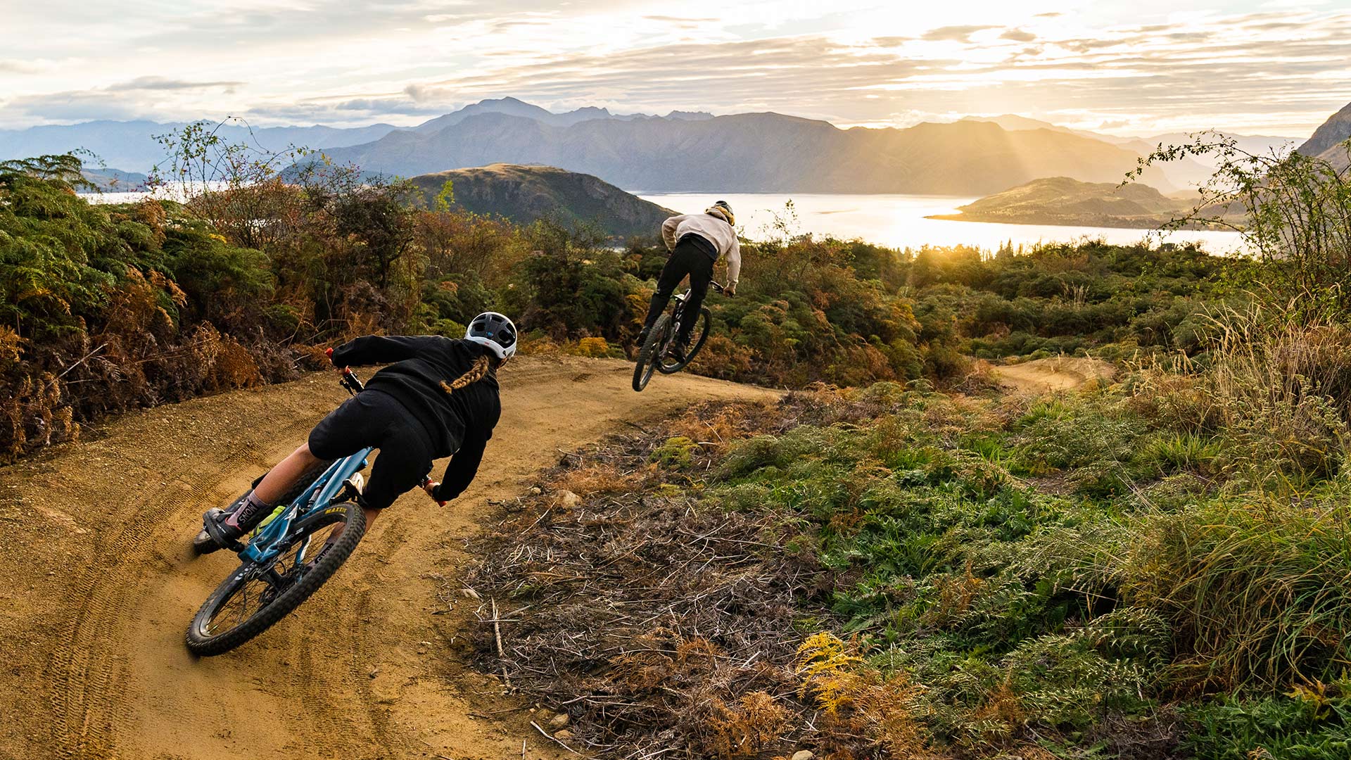 Two mountain bikers riding at Bike Glendhu during golden hour