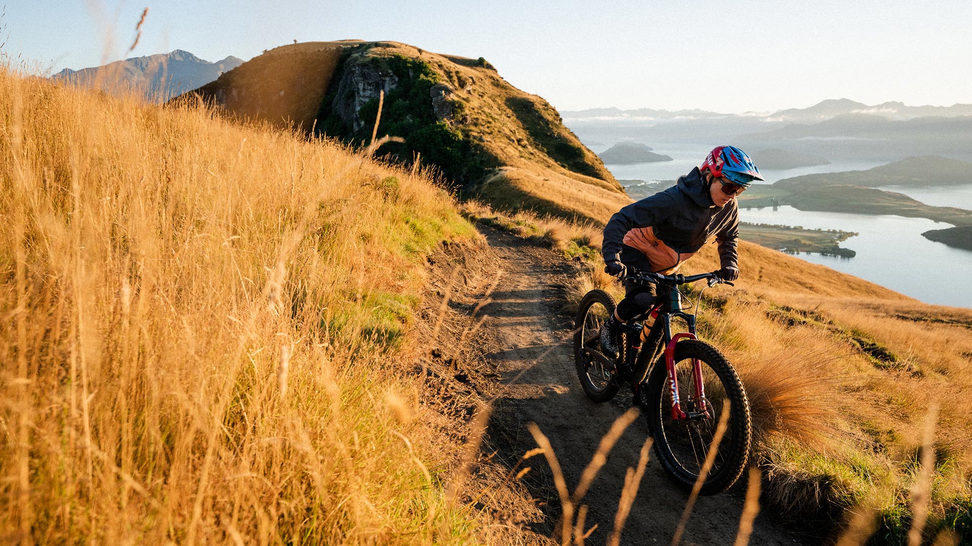 Woman riding uphill trail at Bike Glendhu MTB park in Wanaka, NZ