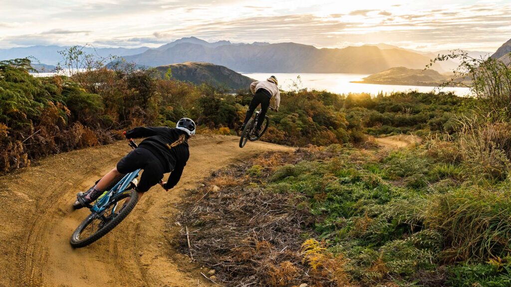 Two mountain bikers riding at Bike Glendhu during golden hour